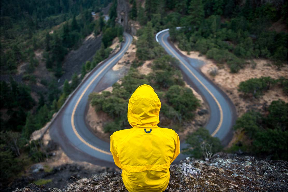 ragazzo su una montagna con kway giallo